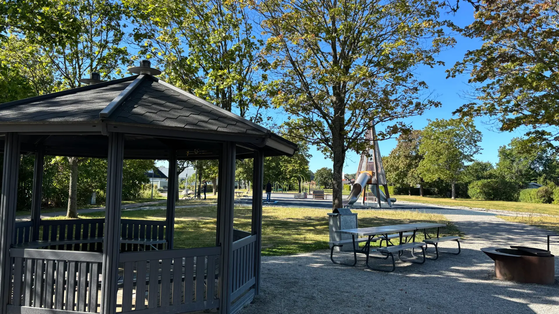 Lusthus och picknickbord i Skeppsparken med lekplatsen i bakgrunden