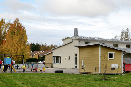 Skörby förskola – gula och ljusa byggnader med lekplan på hösten