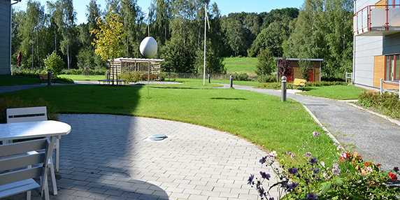 Solängens äldreboendes inhägnade trädgård med promenadgång, gräsmatta och sittplatser
