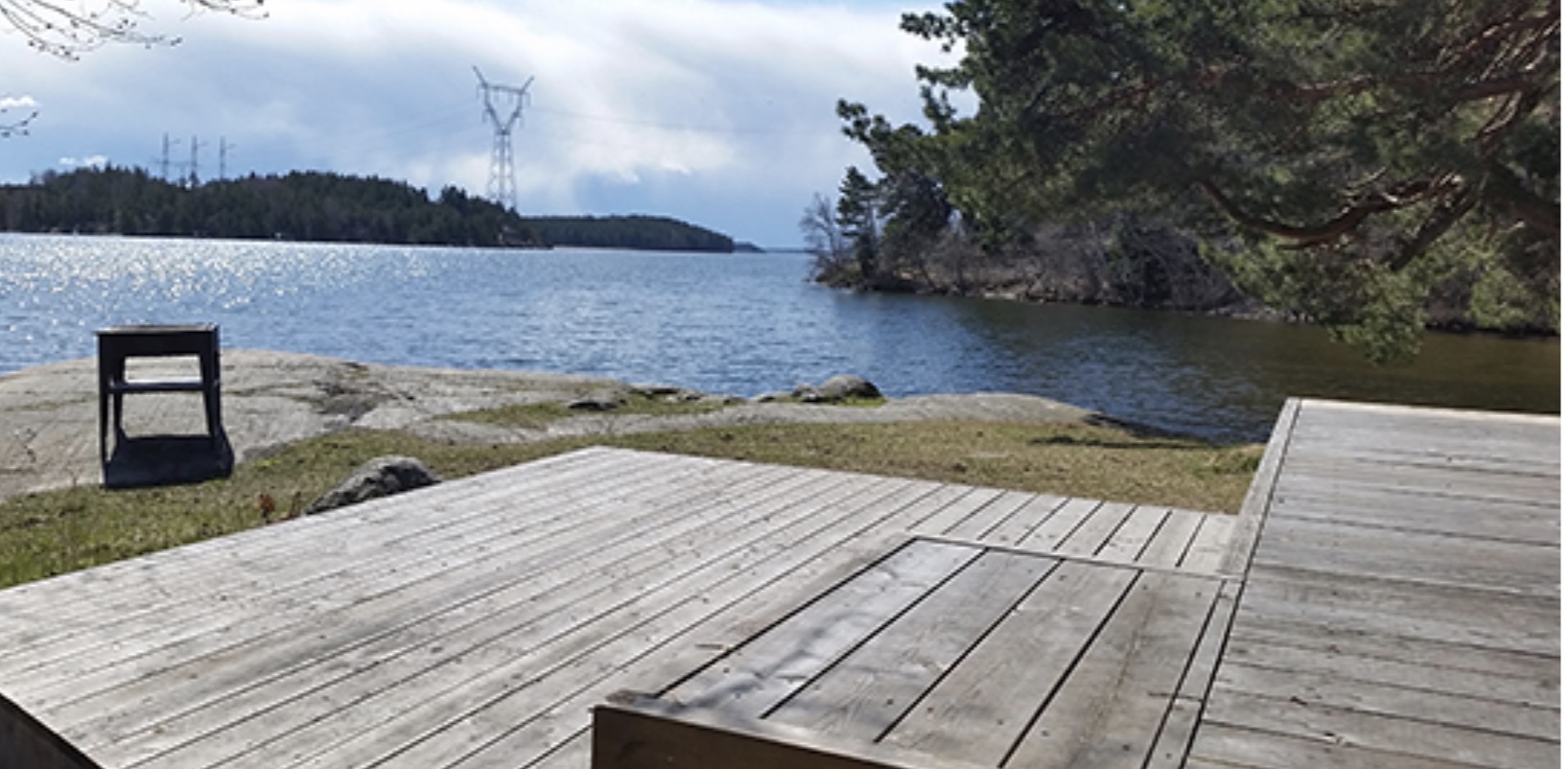 Trädäck och grillplats vid Frösundaviks strandpark med utsikt över Mälaren