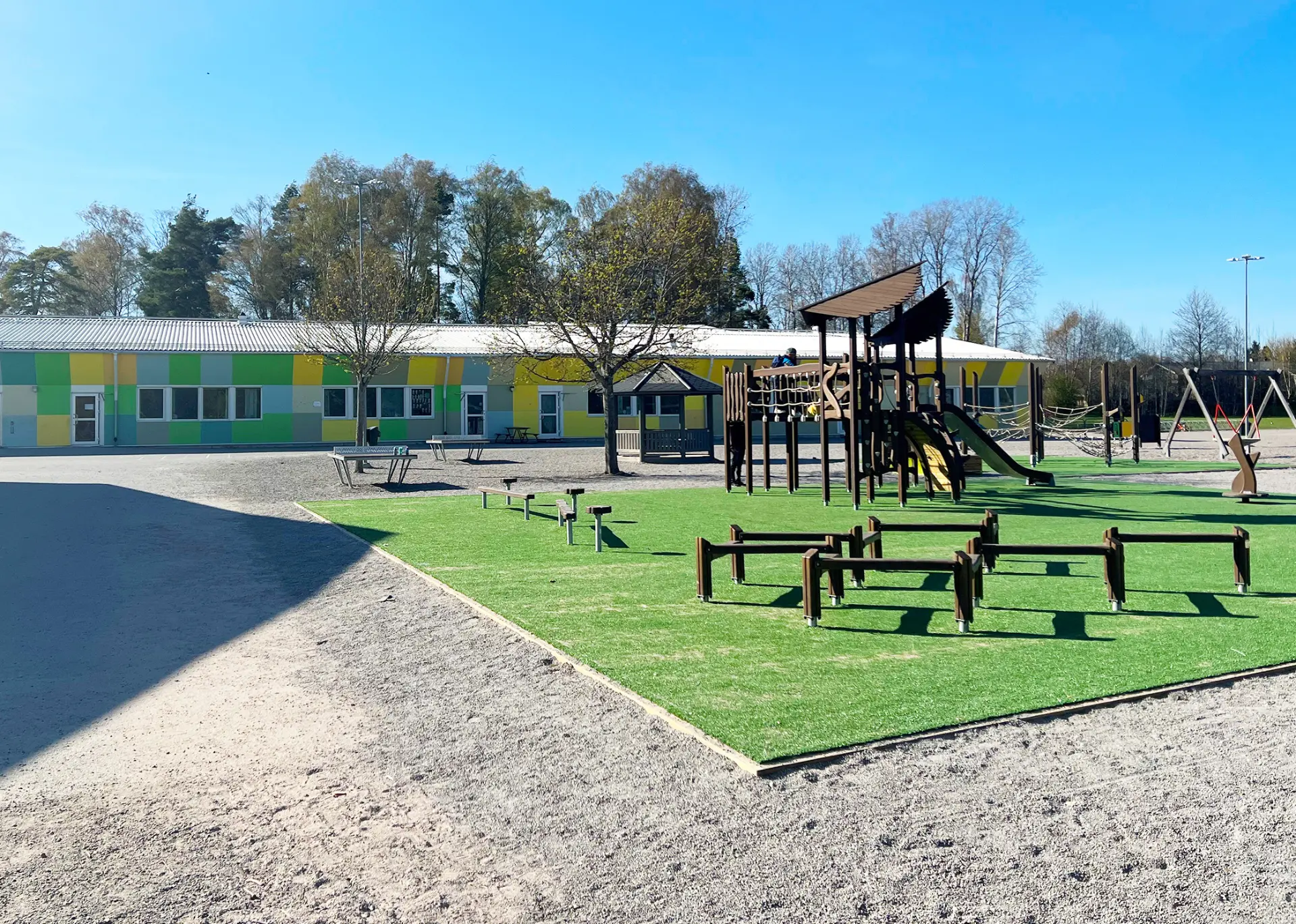 Futurums skolgård i Bålsta med lekplats, aktivitetsytor och den färgglada skolbyggnaden